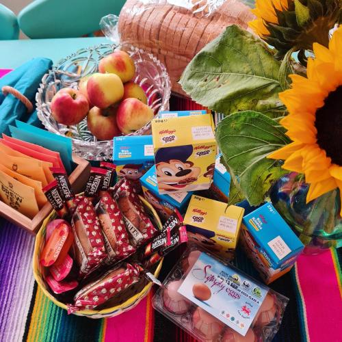 a table topped with a basket of food next to a sunflower at Frida's Cottage Whitby in Whitby