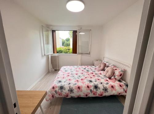 een kleine slaapkamer met een bed met een bloemendeken bij Appt 50m2 /3P refait à neuf proche du métro 8 in Maisons-Alfort
