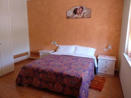 a bedroom with a bed and a picture of a woman on the wall at Affittacamere Dolce Miele in Foligno