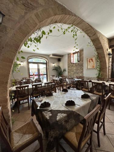 a restaurant with tables and chairs and a brick wall at Il Cantico Suite in Assisi