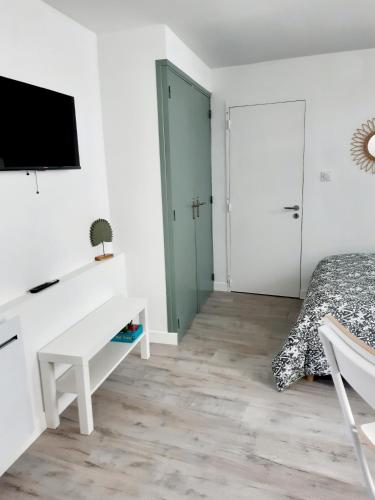 une chambre avec un lit, un bureau et une télévision dans l'établissement Studio Le Refuge, à Champ-sur-Drac