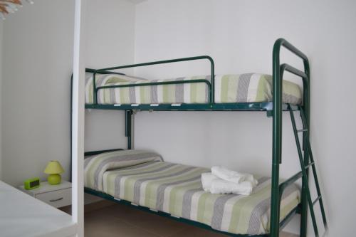 2 stapelbedden in een kamer met een spiegel bij Casa Ventitré in Balestrate