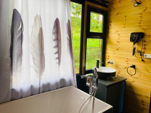ein Badezimmer mit einer Badewanne, einem Waschbecken und einem Duschvorhang in der Unterkunft Inn Martvili in Martvili