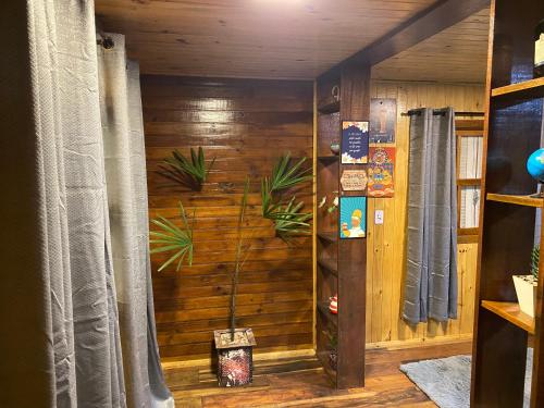um quarto com uma parede de madeira com uma planta em Morada das Estrelas em Cambará
