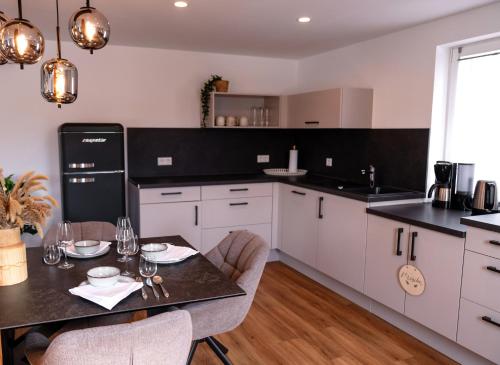 a kitchen with white cabinets and a table with chairs at Zentrale Maisonette-Wohnung in TBB in Tauberbischofsheim