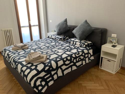 um quarto com uma cama com um edredão preto e branco em Bilocale 5 min Stazione Centrale em Milão