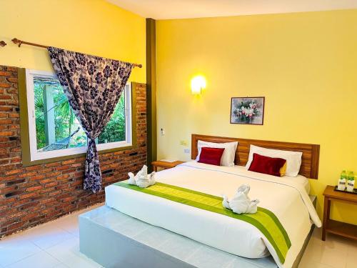 a bedroom with a large bed with two stuffed animals on it at Lanta Baan Nok Resort in Ko Lanta