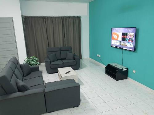 a living room with two couches and a flat screen tv at 4 Bedroom House Indera Mahkota 8 Kuantan Homestay in Kuantan
