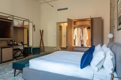 a bedroom with a large bed with blue pillows at Grand Universe La Residenza in Lucca