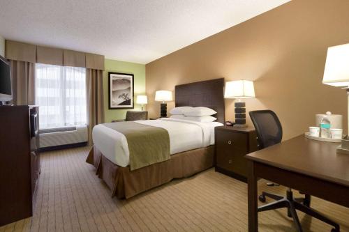 a hotel room with a large bed and a desk at Days Inn by Wyndham Baltimore Inner Harbor in Baltimore
