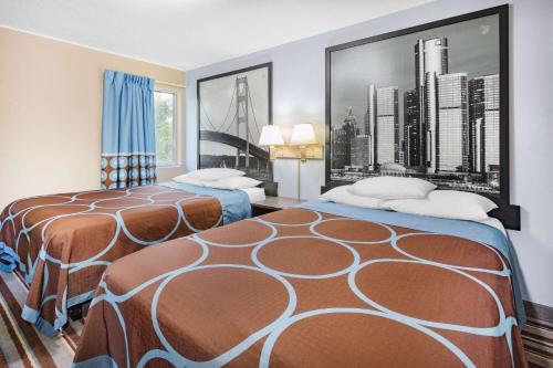 a hotel room with two beds and a picture of a city at Super 8 by Wyndham Marysville/Port Huron Area in Marysville