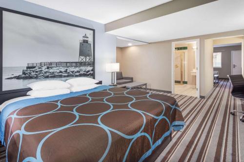 a hotel room with a bed with a painting on the wall at Super 8 by Wyndham Marysville/Port Huron Area in Marysville