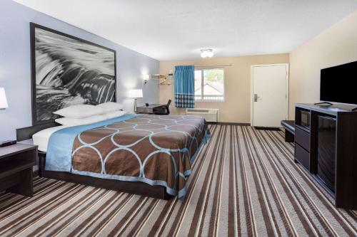a hotel room with a bed and a flat screen tv at Super 8 by Wyndham Marysville/Port Huron Area in Marysville