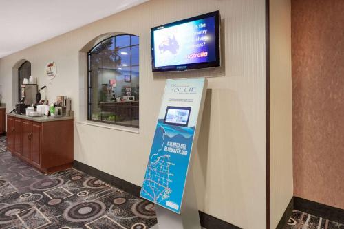a sign on a wall with a tv on a wall at Super 8 by Wyndham Marysville/Port Huron Area in Marysville