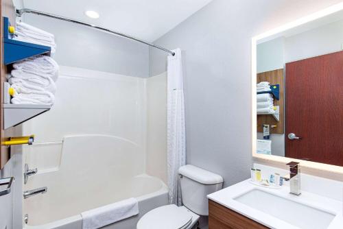 a bathroom with a white toilet and a sink at Microtel Inn & Suites Columbus North in Columbus