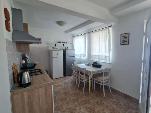 uma cozinha com uma mesa e um frigorífico branco em Apartments Ivan em Zubovici