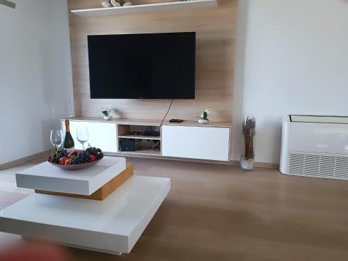 a living room with a flat screen tv on a wall at Vila Frigo Olimia in Podplat