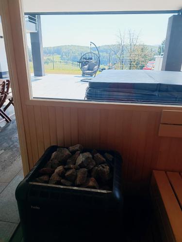 a grill with rocks in front of a window at Vila Frigo Olimia in Podplat