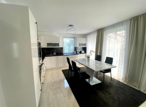 a kitchen and dining room with a white table and chairs at Fewo II Familie Sobierajczyk in Blankenhagen