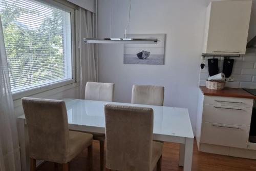 a kitchen with a white table and chairs at Lovely apartment in Itäsatama in Hanko