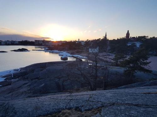 a sunset over a body of water with boats at Lovely apartment in Itäsatama in Hanko