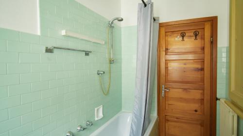 uma casa de banho com um chuveiro, uma banheira e uma porta em Casa Agnese e Rino em Bormio