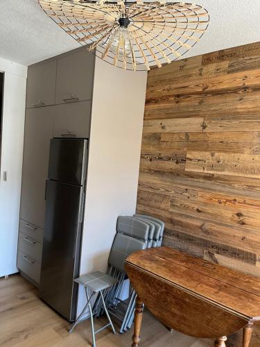 - une cuisine avec un mur en bois, une table et un réfrigérateur dans l'établissement Appartement 4-6 personnes Les 2 Alpes, à Les Deux Alpes