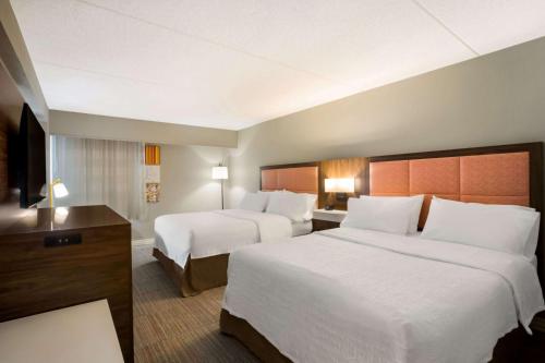 a hotel room with two beds and a television at Hampton Inn Philadelphia/Willow Grove in Willow Grove