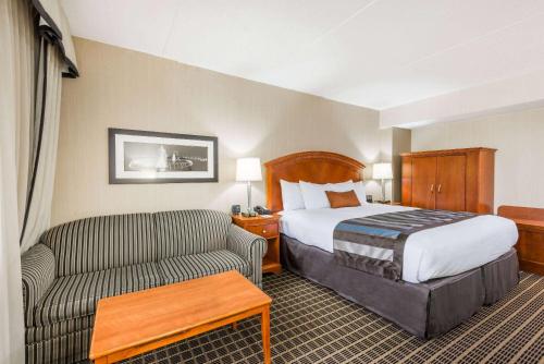 a hotel room with a bed and a couch at Wingate by Wyndham Springfield in Springfield
