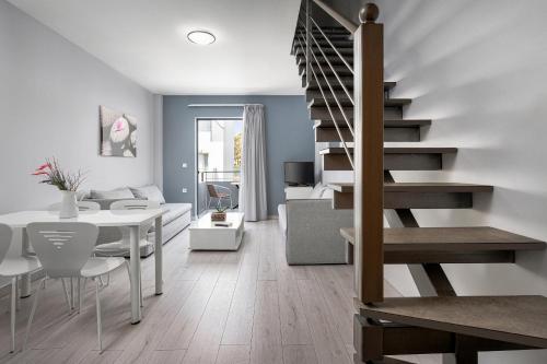a living room and dining room with a spiral staircase at Sunrise Village Hotel - All Inclusive in Plataniás