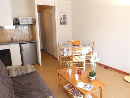 un salon avec une table et une cuisine dans l'établissement Appartement T2 pour 4 à 5 pers, Saint-Lary-Soulan, cuisine équipée, balcon sud, proche services et loisirs - FR-1-457-221, à Saint-Lary-Soulan