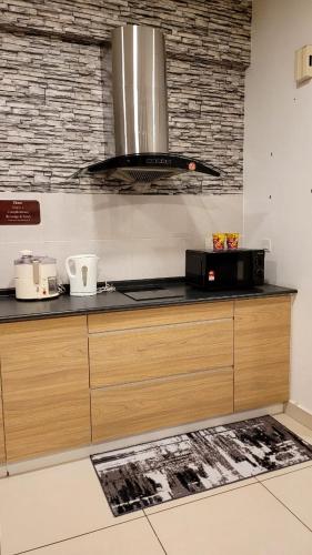uma cozinha com um fogão e uma bancada em Homestay FourSeasons @EVO MALL BANGI em Bandar Baru Bangi
