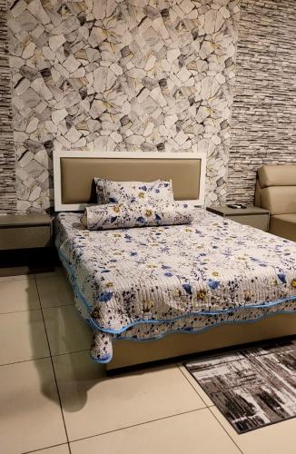 um quarto com uma cama e uma parede de pedra em Homestay FourSeasons @EVO MALL BANGI em Bandar Baru Bangi