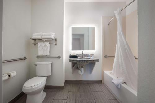 Comfort Suites Denham Springs في دينهام سبرينغز: حمام مع مرحاض ومغسلة وحوض استحمام