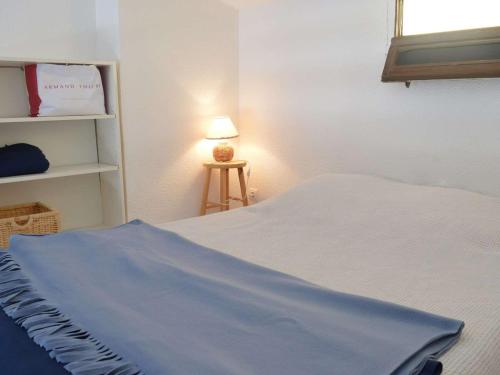 1 dormitorio con 1 cama y 1 mesa con lámpara en Appartement Fleury-Saint-Pierre-la-Mer, 1 pièce, 4 personnes - FR-1-229D-45 en Fleury