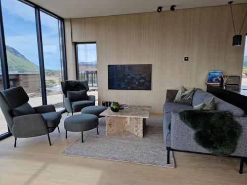 sala de estar con sofá, 2 sillas y mesa en Classy Cabin Lofoten en Kleppstad