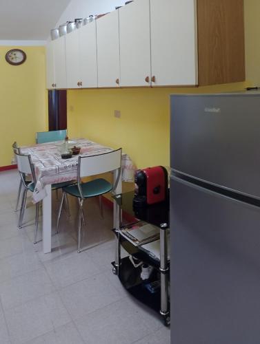 a kitchen with a table and a refrigerator at Casa TildePino davanti al fiume Temo locazione turistica in Bosa