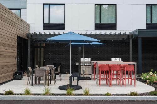 a patio with tables and chairs and an umbrella at Home2 Suites By Hilton Quebec City in Quebec City