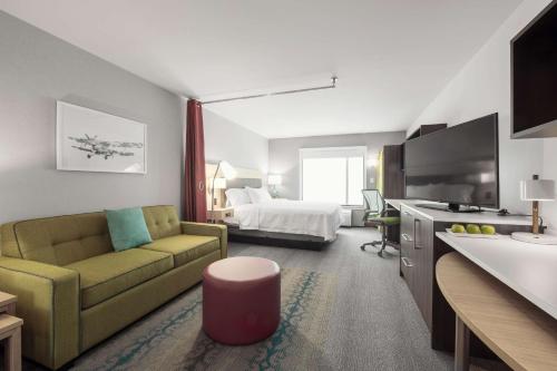 um quarto de hotel com um sofá e uma cama em Home2 Suites By Hilton Quebec City em Quebeque
