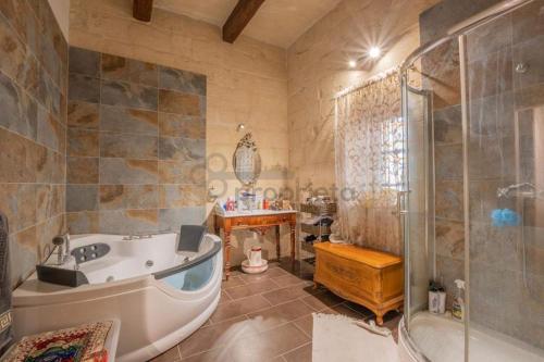 y baño con bañera, ducha y lavamanos. en Vintage Farmhouse, en Qormi