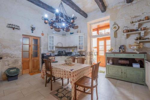 cocina con mesa, sillas y lámpara de araña en Vintage Farmhouse, en Qormi
