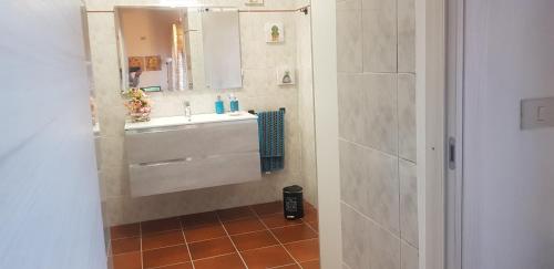 een badkamer met een wastafel en een spiegel bij Anna's House in Lorenzana