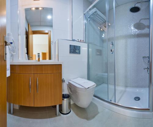 a bathroom with a toilet and a glass shower at Mıen Hotels in Istanbul