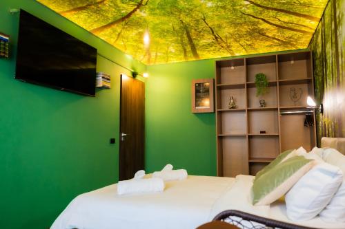 a bedroom with a bed with a green wall at Relaxveld Nature in Curtea de Argeş