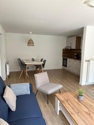 a living room with a blue couch and a table at Ferienwohnung II im idyllischen Gulfhof in Krummhörn