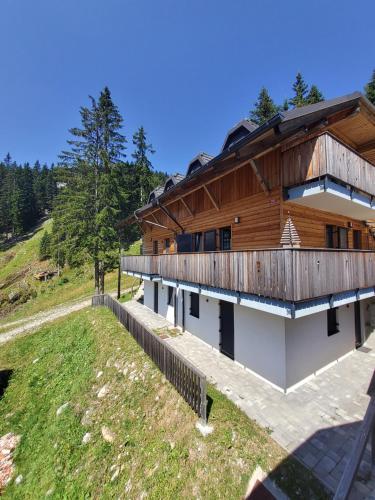 une maison avec un toit en bois sur une colline dans l'établissement Primorka Golte, à Mozirje