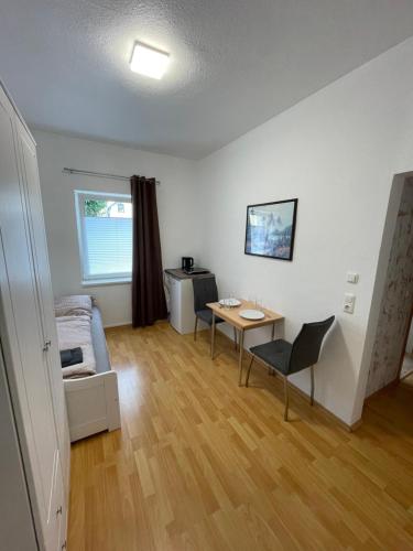 sala de estar con mesa, cama y escritorio en Varus Apartments, en Detmold
