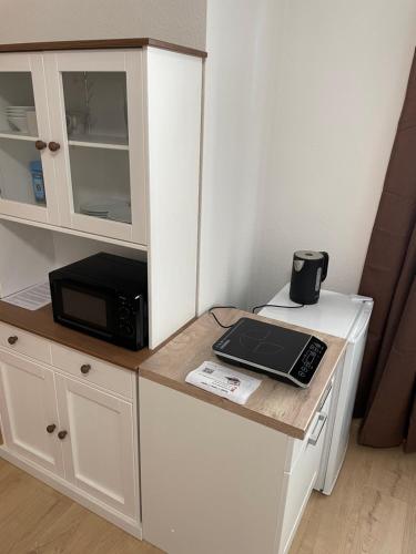 a kitchen with a counter with a microwave and a laptop on it at Varus Apartments in Detmold