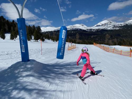 a young girl is skiing down a snow covered slope at Appartement Rosa in Patergassen