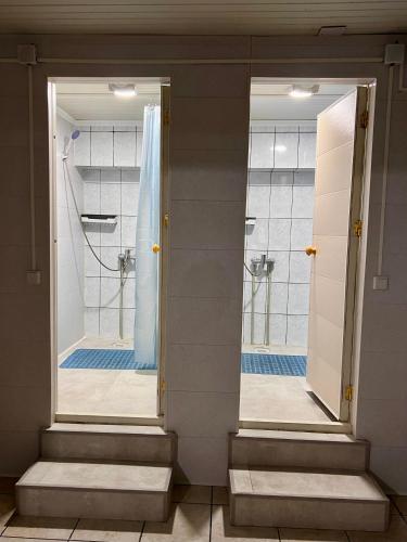 2 espejos en el baño con ducha en InJoy hostel, en Shymkent